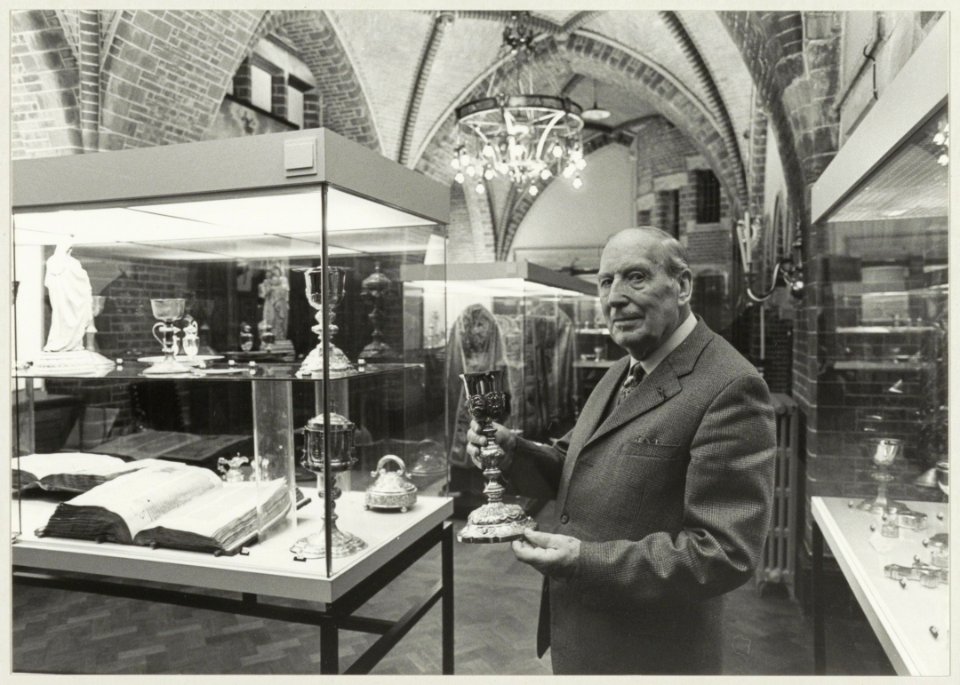 Jo Beijk, schatbewaarder van de Kathedraal St. Bavo stelt enige objecten tentoon. NL-HlmNHA 54011433