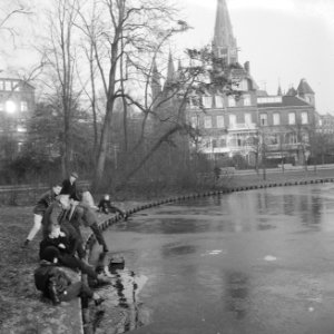 Jongens proberen het eerste ijslaagje in het Vondelpark, Bestanddeelnr 911-9869