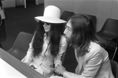 John Lennon en echtgenote Yoko Ono vertrekken van Schiphol naar Wenen in de vert, Bestanddeelnr 922-2498 photo
