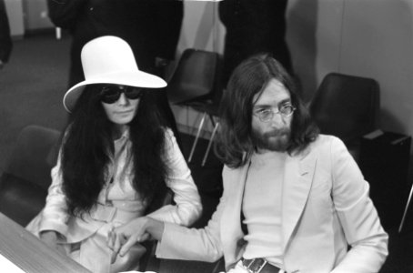 John Lennon en echtgenote Yoko Ono vertrekken van Schiphol naar Wenen in de vert, Bestanddeelnr 922-2499 photo