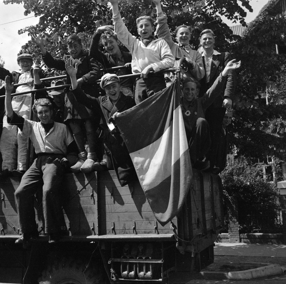 Juichende repatrianten ren in de laadbak van een vrachtwagen, Bestanddeelnr 900-4810