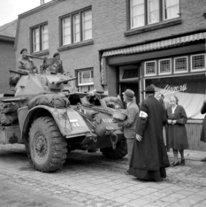 Inwoner van Aalst deelt bij de bevrijding fruit uit aan militairen in pantservoe, Bestanddeelnr 255-9190