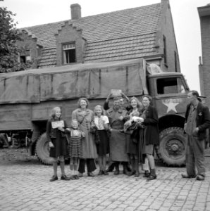 Inwoners van Aalst poserend met een militair van de Irish Guards in hun hand Br, Bestanddeelnr 255-9043