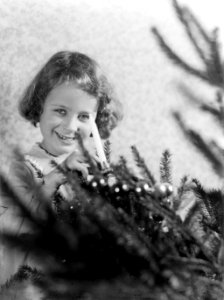 Irmgard zet een kaars in een versierde kerstboom, Bestanddeelnr 189-1122