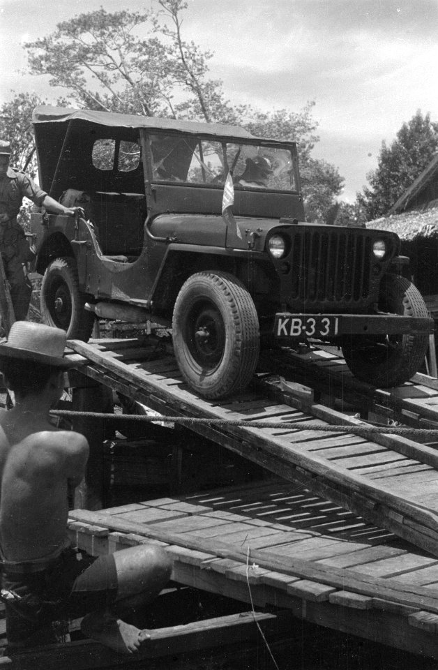 Jeep rijdt over een weg verstevigd met takkenbossen, Bestanddeelnr 6798