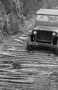Jeep rijdt over een weg verstevigd met takkenbossen, Bestanddeelnr 6799