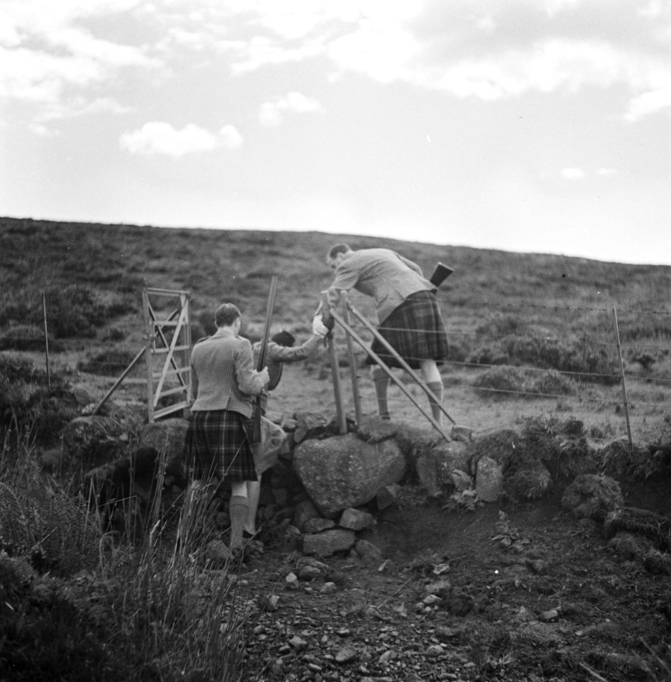 Jagers helpen een vrouw met een opstapje tijdens de jacht op Skye, Bestanddeelnr 254-2849