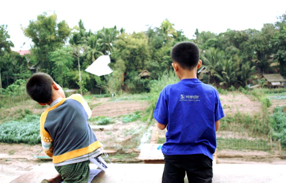 Kids throwing paper planes over river Nam Khan, Luang Prabang