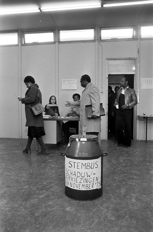 Kiezers in het stemlokaal, op de voorgrond een stembus, Bestanddeelnr 926-8386