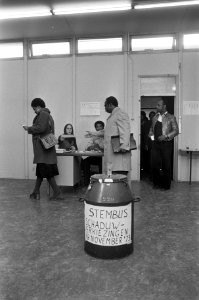 Kiezers in het stemlokaal, op de voorgrond een stembus, Bestanddeelnr 926-8386