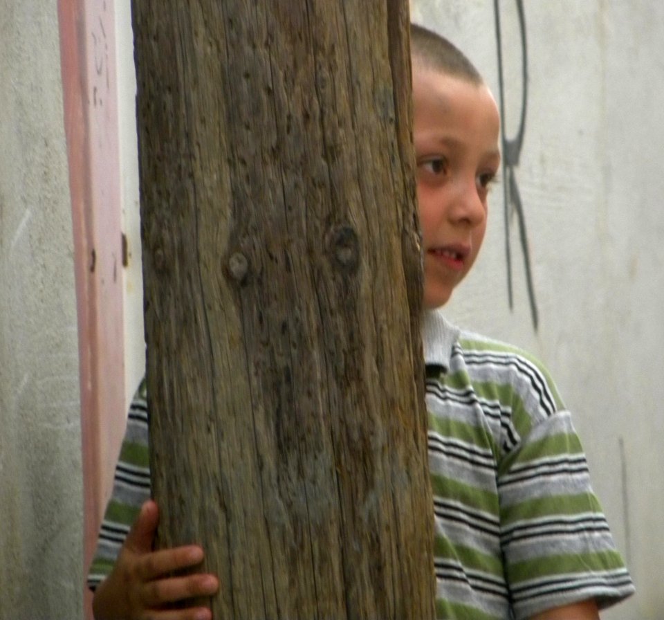 Kid behind wooden power beam