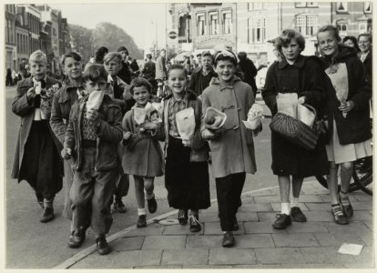 Kinderen nabij de Grote HoutbrugRaamsingel keren huiswaarts met de op de Luilak-bloemenmarkt gekochte planten en bloemen. NL-HlmNHA 54004585