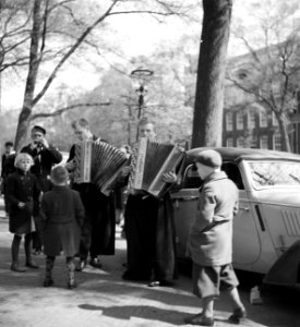 Kinderen op een gracht rond een groep straatmuzikanten in Volendams kostuum, Bestanddeelnr 254-2319