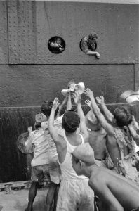 Kinderen op de kade vangen sigaretten die vanaf het schip op de kade gegooid wor, Bestanddeelnr 92-2-3