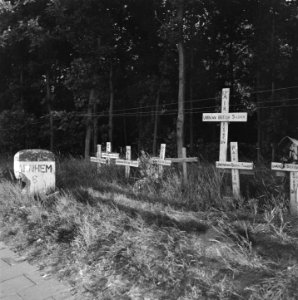 Kilometersteen Arnhem 6 km Daarnaast een reeks graven met houten kruizen, Bestanddeelnr 900-4344