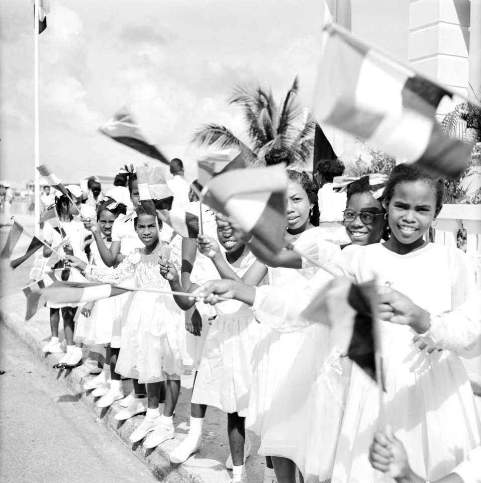 Kinderen met vlaggen bij de aankomst van het koninklijk paar in Willemstad, Bestanddeelnr 252-3573