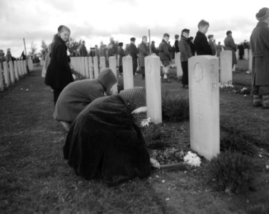 Kinderen leggen bloemen op de graven op de Canadese Erebegraafplaats bij Groesbe, Bestanddeelnr 908-5568