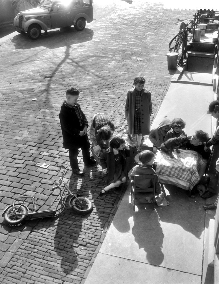 Kinderen spelen in de zon in de Paasvakantie, stoeltjes en tafeltjes naar buiten, Bestanddeelnr 910-2451