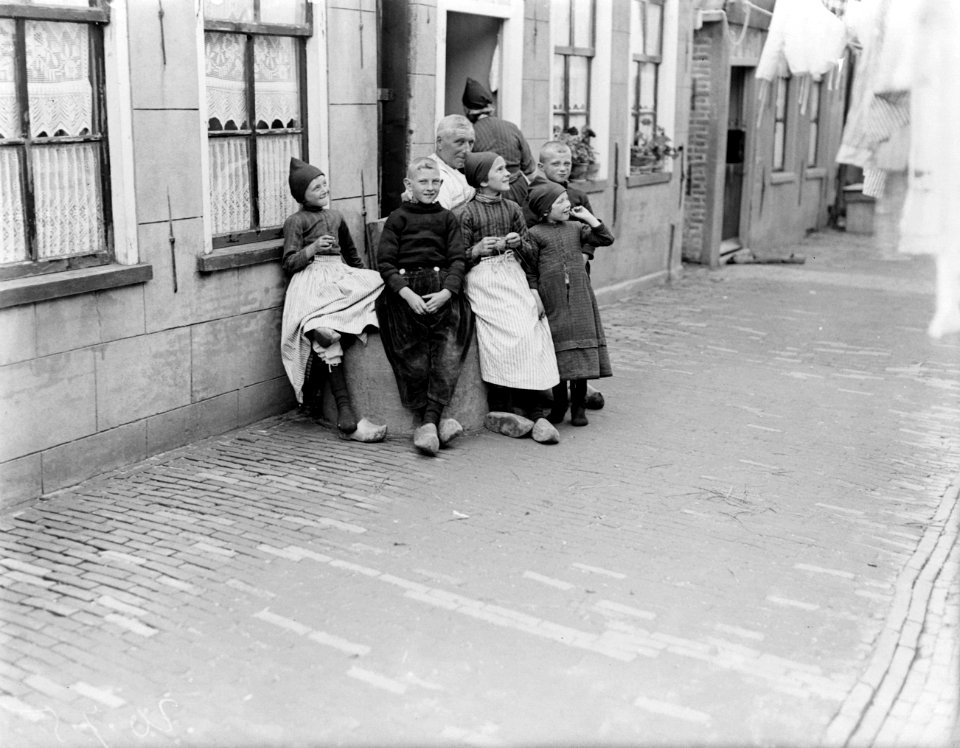 Kinderen rondom een waterput in een straatje in Volendam, Bestanddeelnr 252-0677