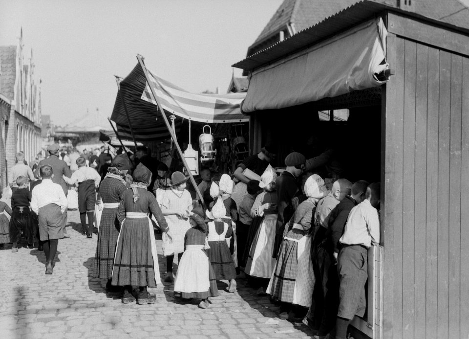 Kinderen in klederdracht in Volendam bij een marktkraam, Bestanddeelnr 190-1125