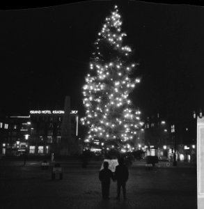 Kinderen bij een met lampen versierde kerstboom op de Dam in Amsterdam, Bestanddeelnr 918-5715