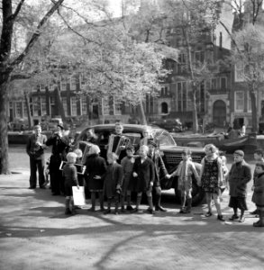 Kinderen op een gracht rond een groep straatmuzikanten in Volendams kostuum, Bestanddeelnr 254-2317