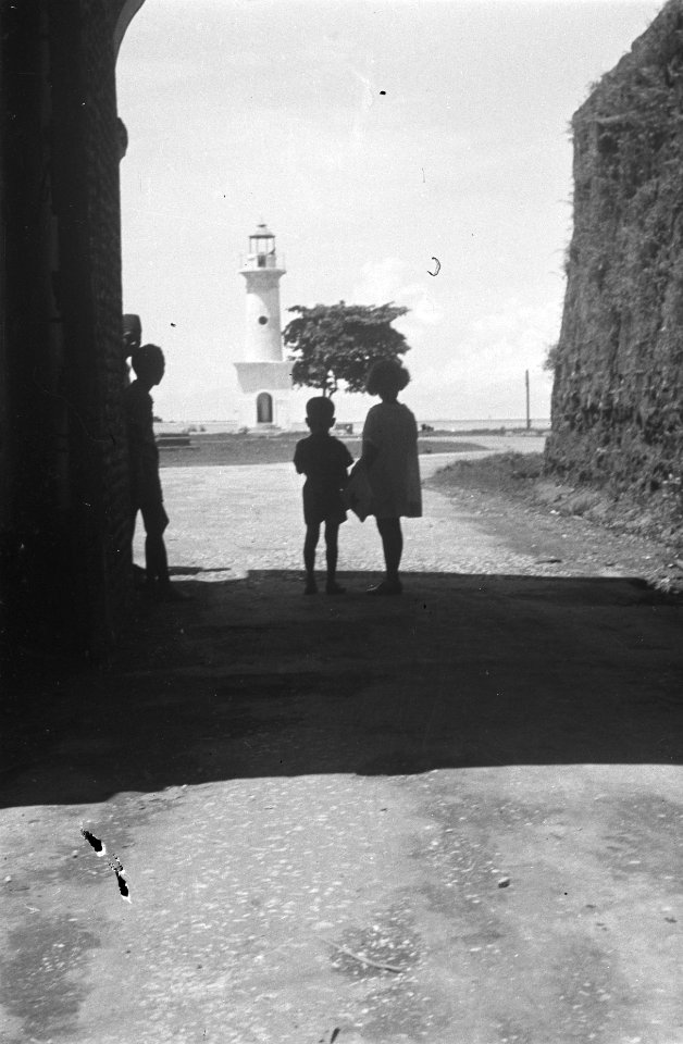 Kinderen in een poort van fort Rotterdam Makassar. Zicht op vuurtoren., Bestanddeelnr 500-4-6
