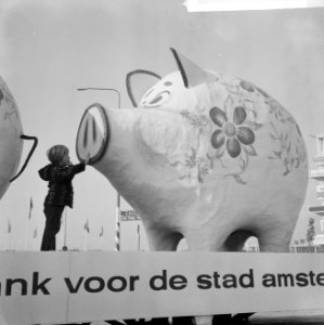Kind dat een van de spaarvarkens van nabij bekijkt, Bestanddeelnr 918-3598