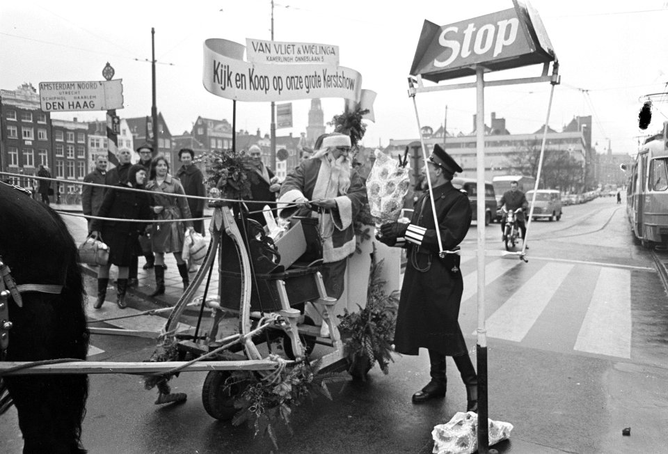 Kerstbloemetje voor verkeersagent op hoek Prins Hendrikkade en Damrak, Bestanddeelnr 920-9402
