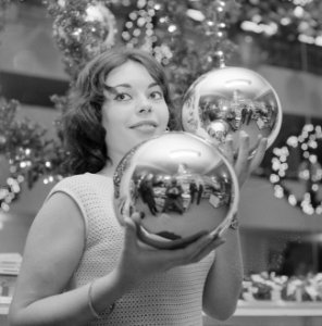 Kerstmis nadert jonge vrouw toont grote kerstballen, Bestanddeelnr 918-5561