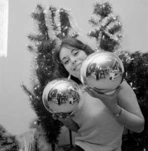 Kerstmis nadert jonge vrouw toont grote kerstballen, Bestanddeelnr 918-5563