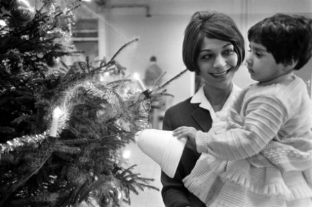 Kerst-welkom op Schiphol, stewardess met meisje uit India bij kerstboom, Bestanddeelnr 919-9006