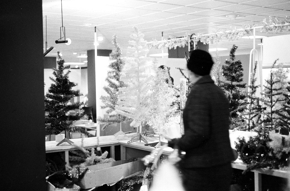 Kerstdrukte in de grote warenhuizen, de stand met gekleur kunstkerstbomen, Bestanddeelnr 914-6259