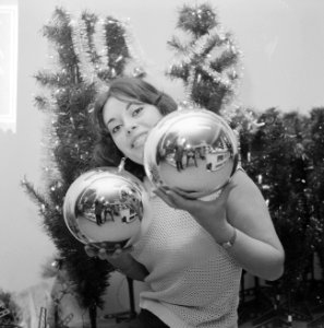 Kerstmis nadert jonge vrouw toont grote kerstballen, Bestanddeelnr 918-5560