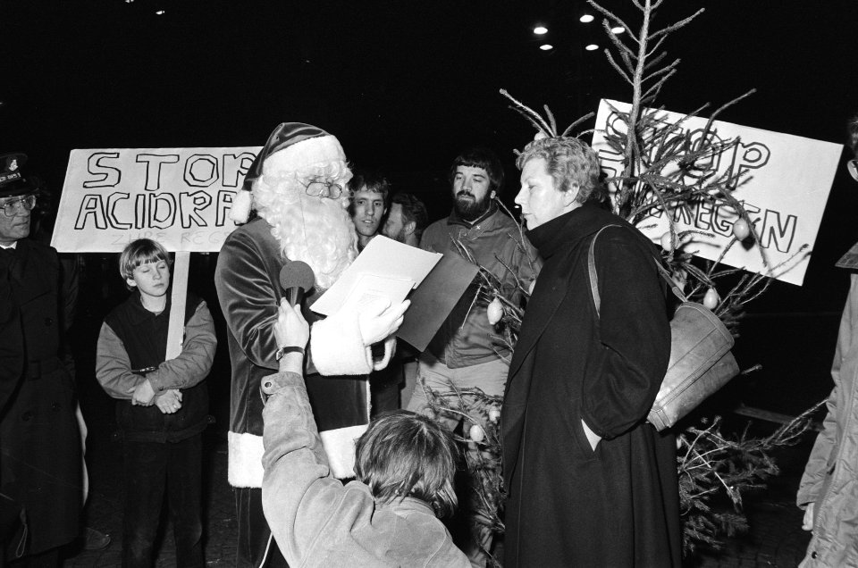 Kerstman van Milieudefensie biedt kerstboom aan wethouder Luimstra aan op de Dam, Bestanddeelnr 933-1770