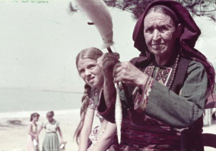 Kleurenfoto van een spinnende vrouw en meisje aan een strand, Bestanddeelnr 254-6558