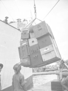 Kisten met persoonlijke bezittingen worden aan boord van een schip gehesen, Bestanddeelnr 13384