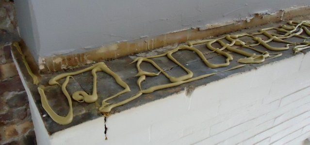 Kitchen renovation 9a construction adhesive on bricks before placing mantle board on top