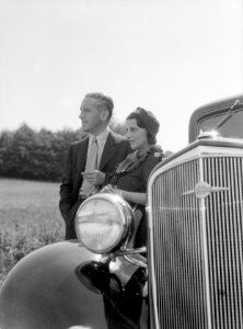 KLM vertegenwoordiger Harry Laponder met zijn schoonzus staande achter een Chevr, Bestanddeelnr 190-0257