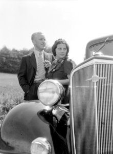 KLM vertegenwoordiger Harry Laponder met zijn schoonzus staande achter een Chevr, Bestanddeelnr 190-0256