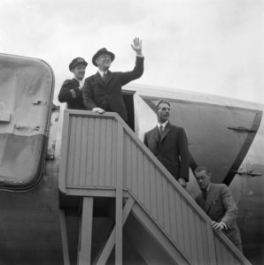 KLM Man (Plesman) zwaait vanaf vliegtuigtrap van een militair vliegtuig, Bestanddeelnr 901-8375
