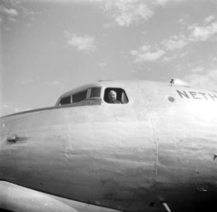 KLM-vlieger GJ Geysendorffer kijkt uit het raam van de cockpit op het vliegvel, Bestanddeelnr 254-2308