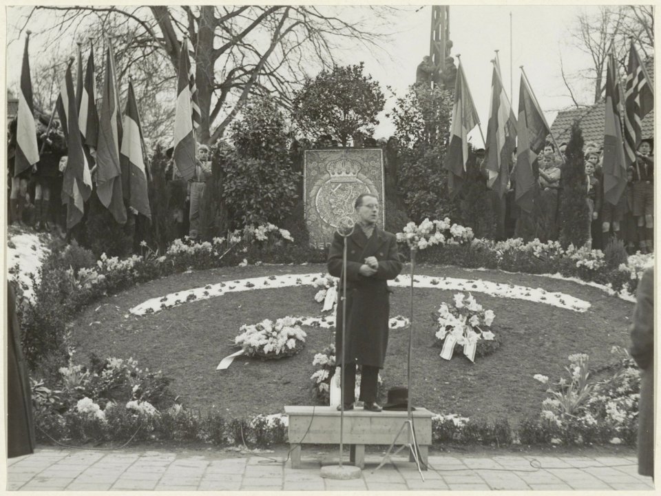 Kapelaan Bregter spreekt tijdens een herdenkingsbijeenkomst bij het voorlopige verzetsmonument aan de Dreef, ziende naar het oosten. NL-HlmNHA 54005283