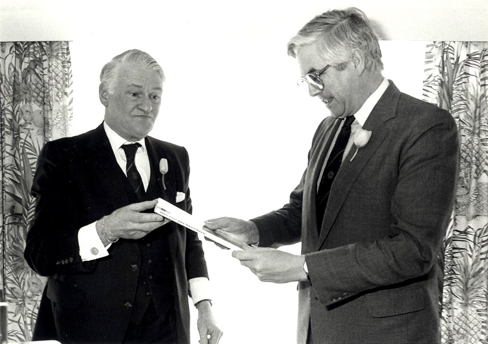 Kamer van Koophandel aan het Nassauplein 2 - 8. Staatssecretaris Frits Bolkestein ontvangt het boek Import en Export Gilde Haarlem-Holland. Geschonken in 1986 door United Photos de Boer bv. Negatiefnu