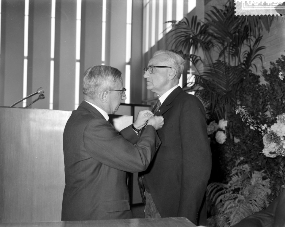 Kamer van Koophandel 150 jaar . De Quay speldt de medaille op bij Mr. G. M. Greu, Bestanddeelnr 912-4180