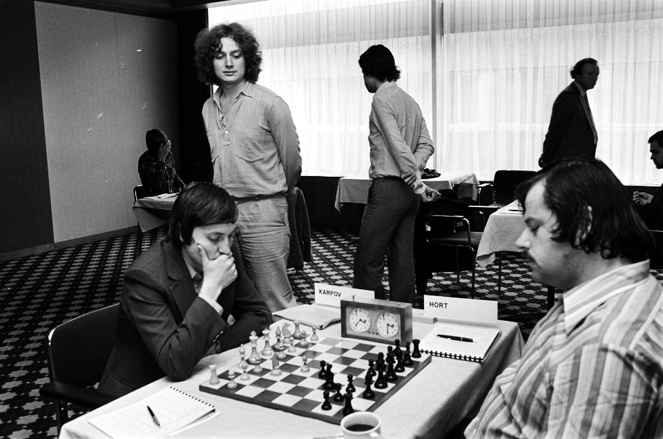 Karpov (l) speelt tegen Hort Timman (staand) kijkt mee, Bestanddeelnr 930-9151