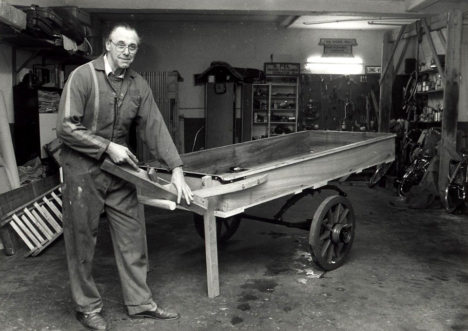 Korte Lakenstraat 11. Het marktkramen verhuurbedrijf Ben Pel bij de door hem gerestaureerde handkar. Aangekocht in 1989 van United Photos de Boer bv. - Negatiefnummer 28632 k 17. - Gepubliceerd in het