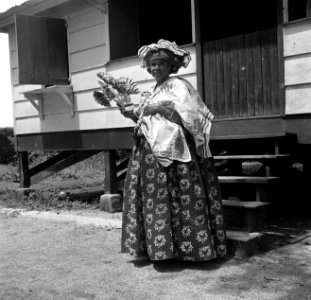 Kotomisi Pauline voor het gouvernementslogeerhuis in Nieuw-Nickerie gekleed in f, Bestanddeelnr 252-5454