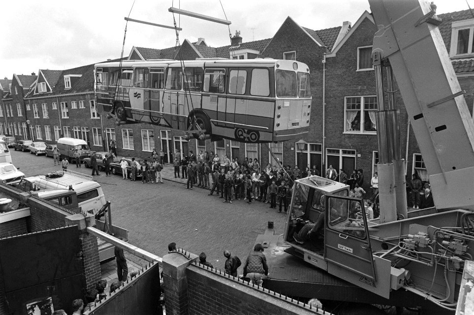 Kraan hijst gemeenstebus over schutting derde Technische School (Timorplein) waa, Bestanddeelnr 932-2110