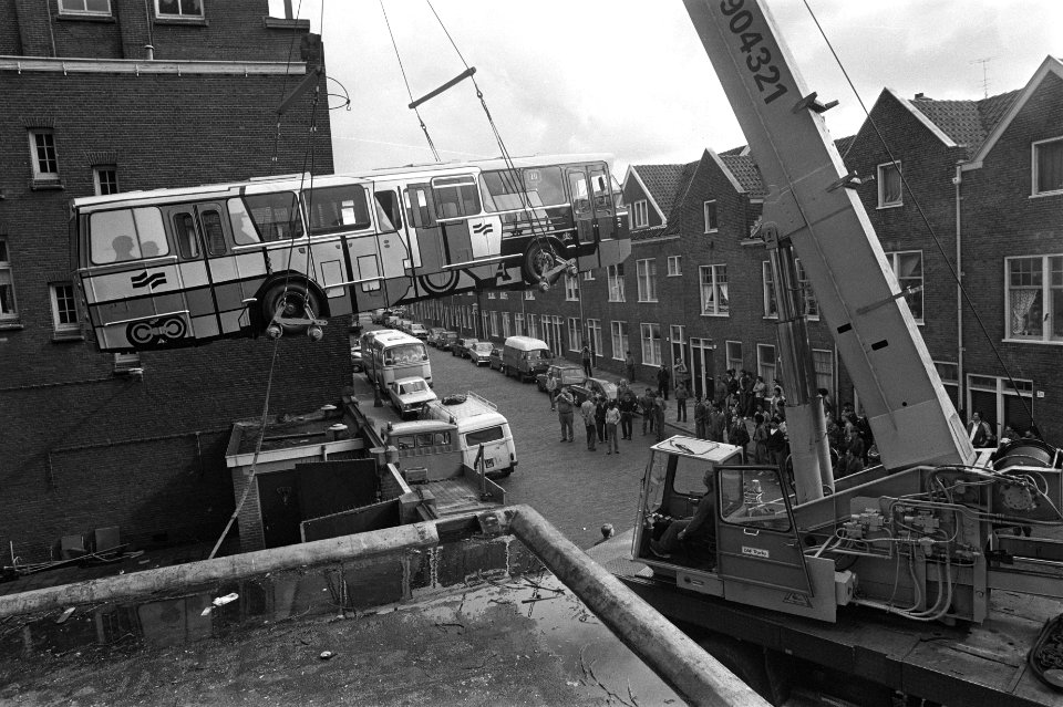 Kraan hijst gemeenstebus over schutting derde Technische School (Timorplein) waa, Bestanddeelnr 932-2111